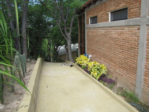 a walkway next to a brick building with flowers at Centro Sati Bungalos in Cuatunalco