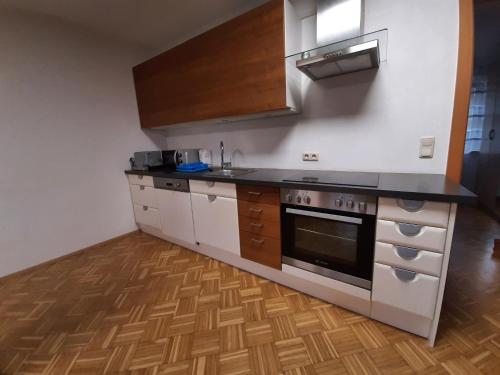a kitchen with white cabinets and a stove top oven at Schöne Wohnung am Bauernhof in Lehen