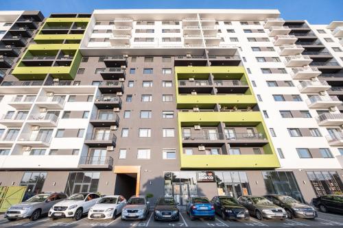 wysoki budynek mieszkalny z samochodami zaparkowanymi na parkingu w obiekcie KM Flats w mieście Oradea