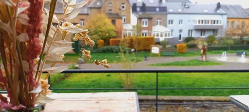 a vase of flowers on a table with a view of a yard at Gîte Chez Simone in Houffalize