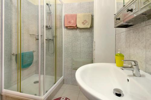 bagno bianco con doccia e lavandino di Palheiro Residence Familiar 1 a Funchal