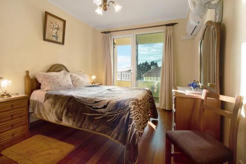 1 dormitorio con 1 cama con tocador y ventana en Palheiro Residence Familiar 1, en Funchal
