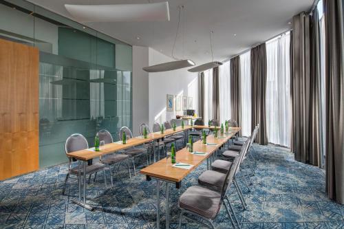 a row of tables and chairs in a room with windows at Quality Hotel Brno Exhibition Centre in Brno