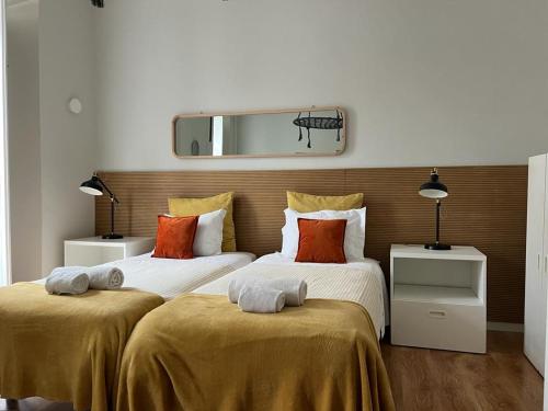 リスボンにあるAlfama Dream Apartmentsのベッドルーム1室(ベッド2台、壁掛け鏡付)