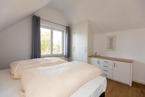Habitación blanca con cama y ventana en 4 Zimmer Maisonette 3 Balkone Haus 6 A6 Nr 43 en Plau am See