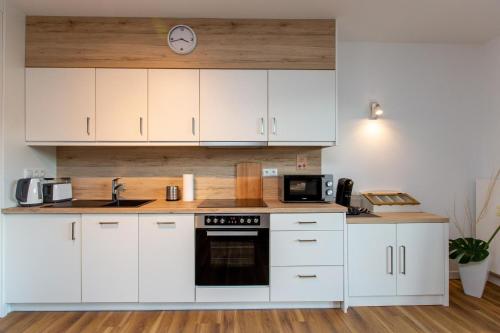 a kitchen with white cabinets and a stove top oven at Becci's Apartment P6A8 in Plau am See
