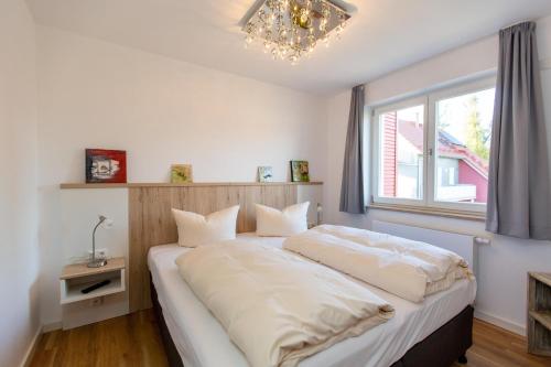 ein Schlafzimmer mit einem großen Bett mit Fenster in der Unterkunft Becci's Apartment P6A8 in Plau am See