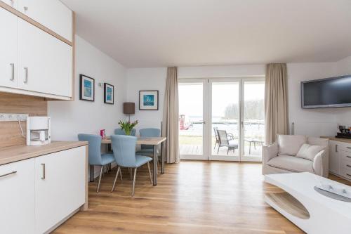 een keuken en een woonkamer met een tafel en stoelen bij Haus 7 Apartment 2 Hundefreundlich in Plau am See