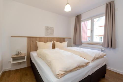 una camera da letto con un grande letto con lenzuola bianche e una finestra di 2 Zimmerapartment Nr45 P6A2 a Plau am See