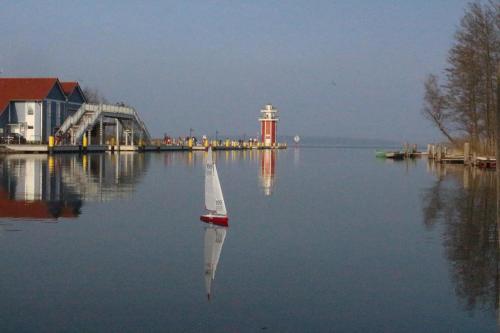 a small boat in the water next to a building at Leuchtturmblick Haus 6 A 5 in Plau am See