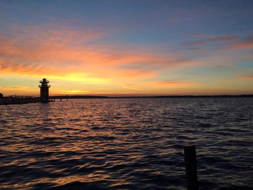 a sunset over a body of water with a lighthouse at Leuchtturmblick Haus 6 A 5 in Plau am See