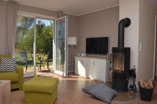 sala de estar con chimenea y TV en Apartment PlauSeelig mit Bootsliegeplatz optional, en Plau am See