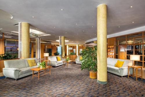 a lobby with couches and plants in a building at Quality Hotel Brno Exhibition Centre in Brno