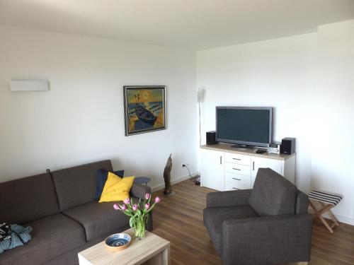 a living room with a couch and a tv at Haus 6 Apartment 3 in Plau am See