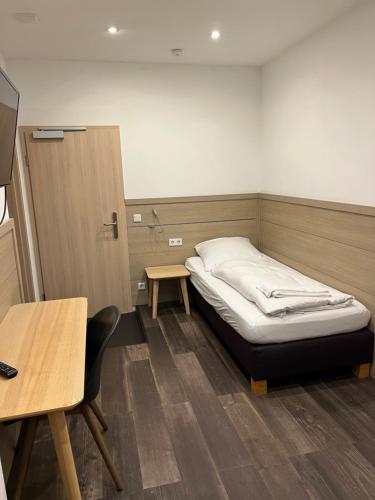 Zimmer mit einem Bett, einem Tisch und einem Schreibtisch in der Unterkunft Slamba Hostel in Augsburg