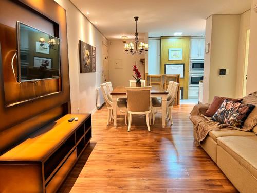 un soggiorno e una sala da pranzo con divano e tavolo di Home GRAMADO- 400 metros da Rua Coberta a Gramado
