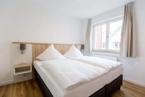 a large white bed in a room with a window at Whg_ _Hafenparadies_ P6A7 optional in Plau am See