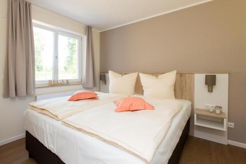 a bedroom with a large white bed with two pillows at Hafenperle P5A5 Nr37 in Plau am See