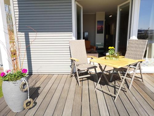 a patio with a table and chairs on a deck at 2 Zimmerapartment 2 Terrassen P7a1 in Plau am See