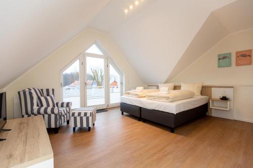 a attic bedroom with a bed and a chair at Apartment mit 3 Schlafzimmer P5A7 in Plau am See