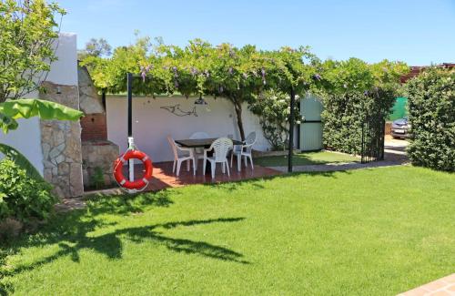 a garden with a table and chairs under an arbor at Chalet Dehesa Villa in Conil de la Frontera