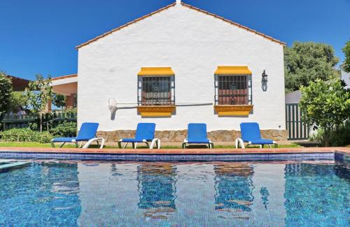 a group of blue chairs next to a swimming pool at Chalet Dehesa Villa in Conil de la Frontera