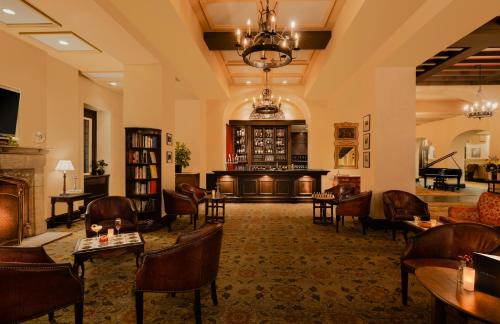 a lobby with a fireplace and a piano at Fairmont Le Manoir Richelieu in La Malbaie