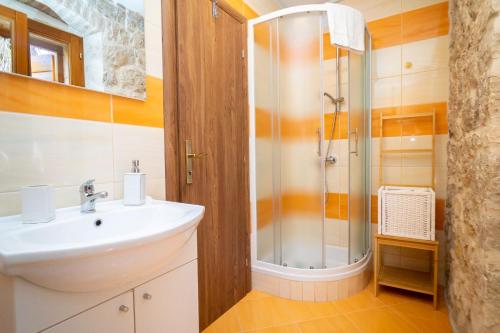a bathroom with a sink and a shower at Apartments and Rooms Marino in Trogir