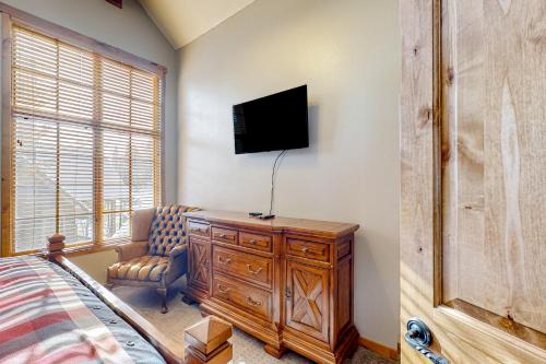 a bedroom with a bed and a tv and a chair at Need for Speed in Donnelly