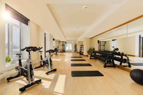 a gym with a row of treadms and pilates equipment at Fairmont Le Manoir Richelieu in La Malbaie
