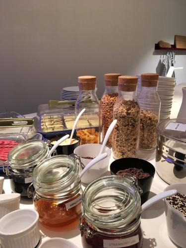 a table topped with jars of cereal and other food items at Hotel Light in Rotterdam