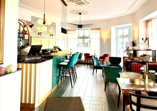 um restaurante com cadeiras verdes e um bar em Best Western Hotel Kurfürst Wilhelm I. em Kassel