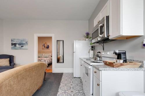 a kitchen with white cabinets and a white refrigerator at G5 KING BED central location museums FREE PARKING in Richmond