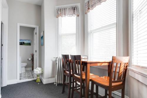 a dining room with a table and some windows at G5 KING BED central location museums FREE PARKING in Richmond
