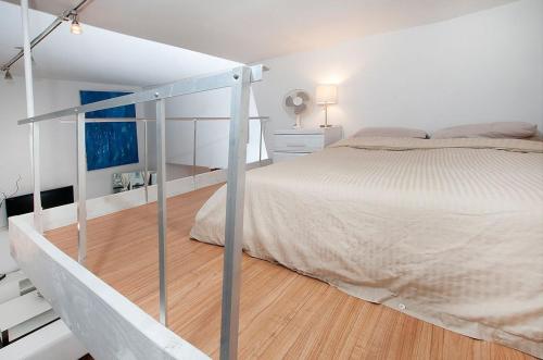 a white bedroom with a bed and a staircase at Park Ave Apartments Midtown Next to Times Square in New York