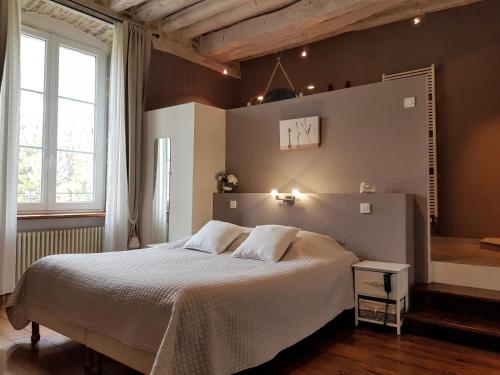 1 dormitorio con 1 cama blanca grande. en Maison d'Eusébia, en Château-Chalon