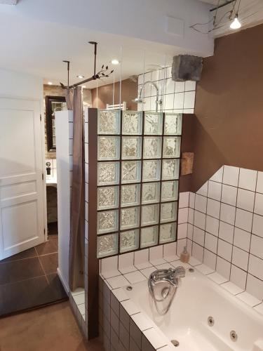 a bathroom with a bath tub in a room at Maison d'Eusébia in Château-Chalon