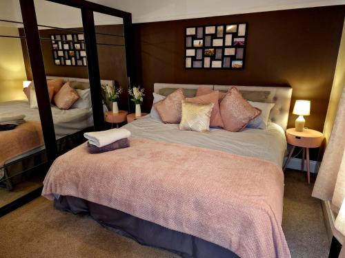 a bedroom with a large bed with two mirrors at The Nook Cosby Village 
