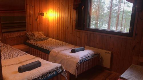 a bedroom with two beds and a window in it at Villa Rapakivi in Heinola
