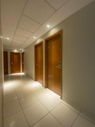 an empty hallway with wooden doors in a building at Rota 232 Hotel Caruaru in Caruaru