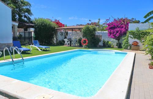 a swimming pool in the backyard of a house at Chalet la Dehesa in Conil de la Frontera