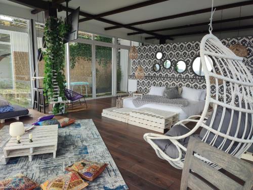 a living room with white chairs and a couch at Sukha Resort in La Calera