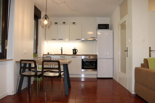 a kitchen with a table and chairs and a refrigerator at Apartments ZVEZDICA*** with garden in Zambratija