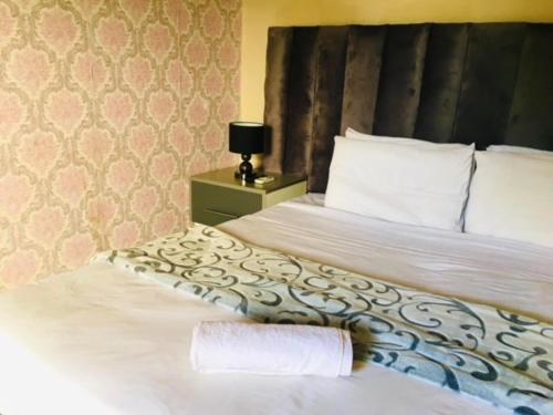 a hotel room with a bed with a towel on it at Lamamie Suite Lodge in Thohoyandou