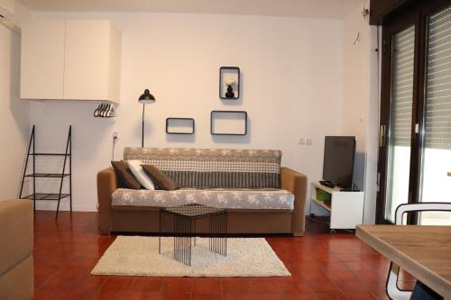 uma sala de estar com um sofá e uma mesa em Apartments ZVEZDICA*** with garden em Zambratija