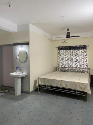 a bedroom with a bed and a sink and a mirror at Maria's Homestay in Siliguri