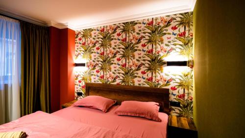 a bedroom with a bed with two pink pillows at Anbani Apartments - City Center in Tbilisi City