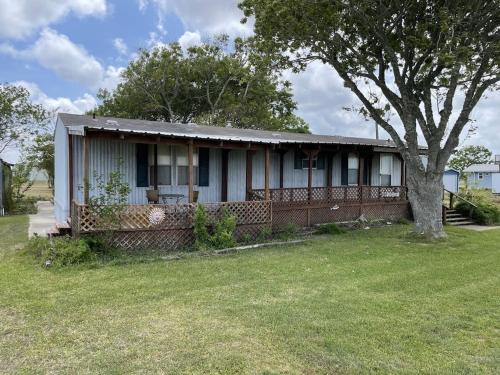 an old house with a tree in the yard at Edgewater Getaway in Port Lavaca