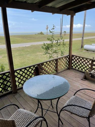 a table and chairs on a porch with a view of a field at Edgewater Getaway in Port Lavaca