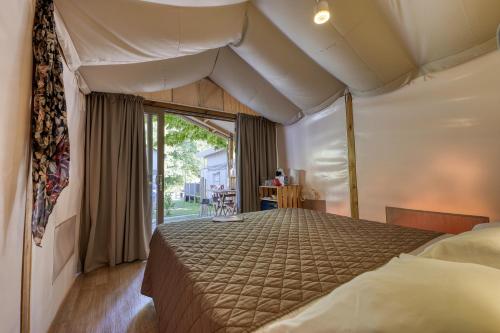 1 dormitorio con 1 cama grande en una habitación en Camping Eden Glamping, en Dormelletto